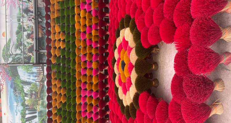 Bunte Räucherstäbchen in einem blumenähnlichen Muster angeordnet.