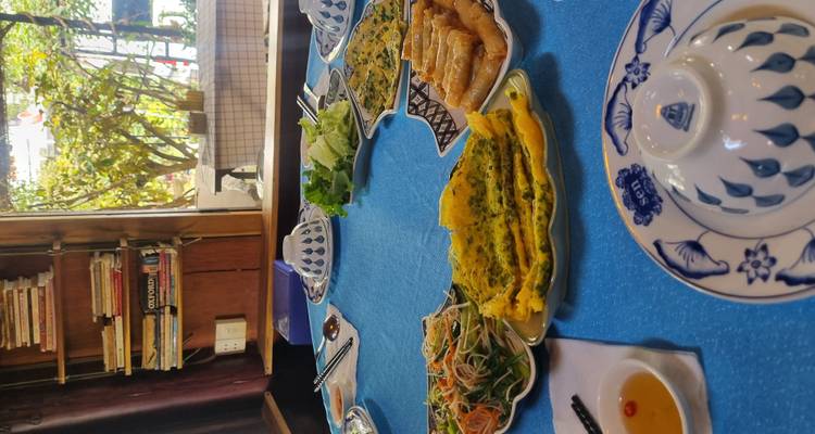 Comida vietnamita servida en una mesa con platos y palillos.