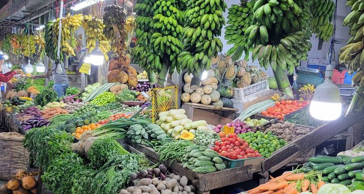Étal de marché rempli d'une variété de fruits et légumes.