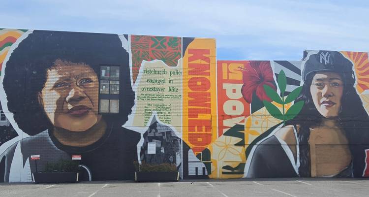 Farbenfrohe Wandmalerei mit künstlerischen Porträts an einer Gebäudewand.