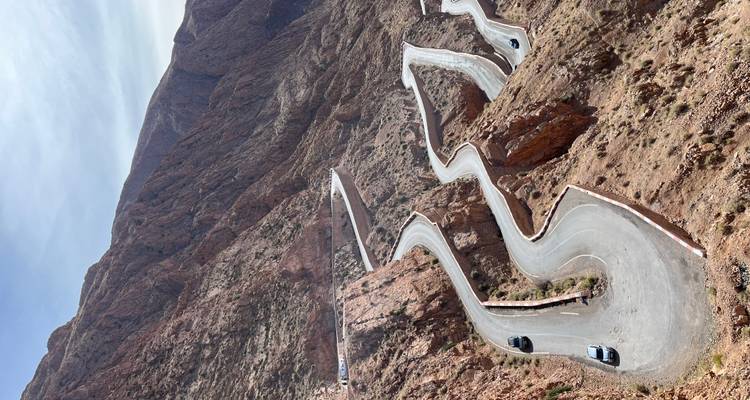 Malerische kurvenreiche Straße durch raue Berglandschaft.