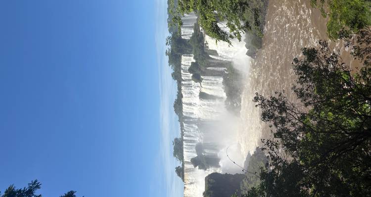 View of Iguazu Falls with clear blue skies and lush greenery.