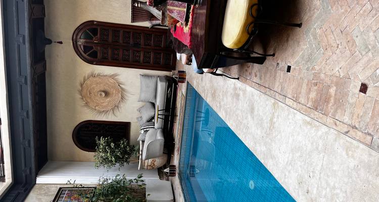 Cozy courtyard with a private pool, seating, and plant decoration, creating a charming atmosphere.
