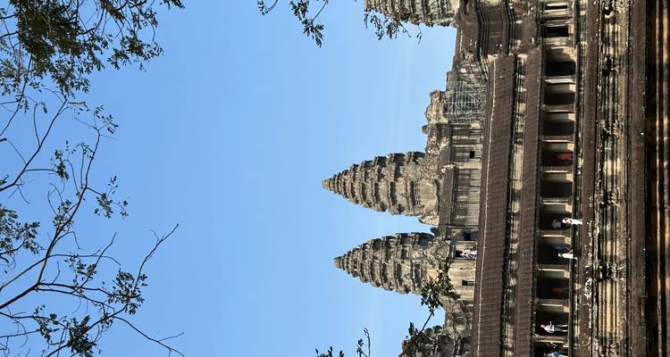 Tours emblématiques triples d'Angkor Wat s'élevant au-dessus de la galerie principale avec des touristes explorant en contrebas.