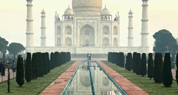Vista simétrica icónica del Taj Mahal con estanque reflectante flanqueado por cipreses