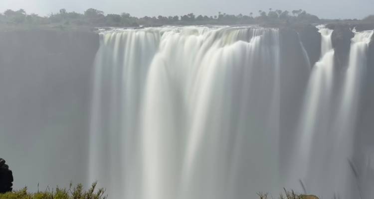 Puissant rideau des chutes Victoria capturé avec une exposition longue soyeuse et de la brume qui s'élève.