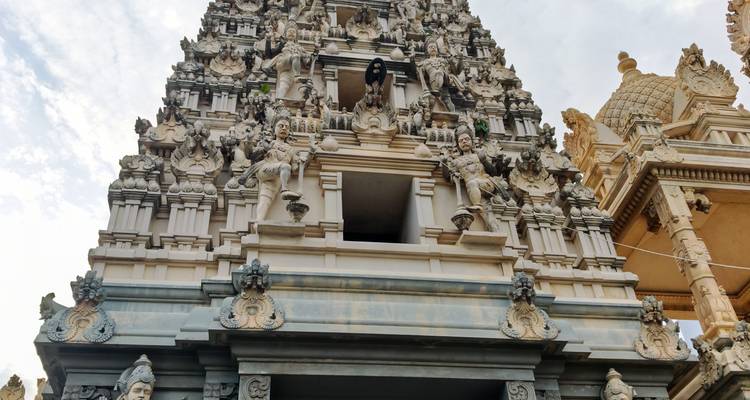 Gopuram ornamentado de un templo hindú ricamente decorado con esculturas contra el cielo.