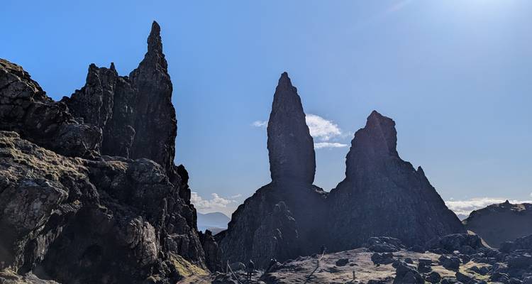 Des flèches de basalte déchiquetées du Vieil Homme de Storr dominent un paysage ensoleillé des Highlands