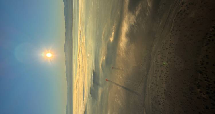 Amanecer aéreo sobre valles llenos de niebla con las sombras de globos aerostáticos proyectadas en la neblina de abajo