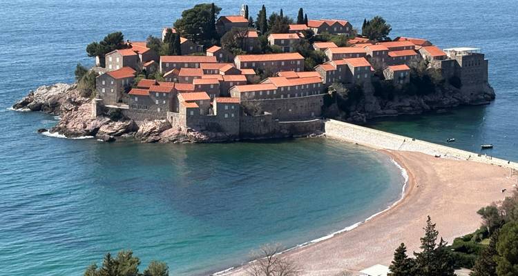 Iconisch versterkt eiland Sveti Stefan dat uitsteekt in de turquoise wateren van de Adriatische Zee onder een heldere hemel.