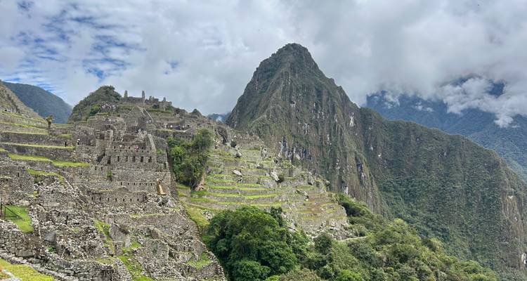 Vue panoramique emblématique des ruines de Machu Picchu avec le pic Huayna Picchu qui se dresse derrière.
