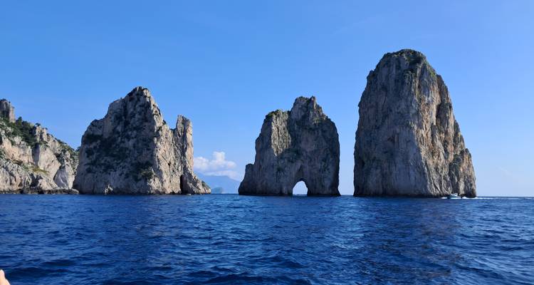 Icónicos farallones Faraglioni que se elevan dramáticamente desde las aguas azul profundo cerca de la isla de Capri.