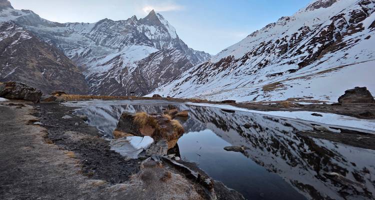Pico del Himalaya cubierto de nieve reflejándose perfectamente en un estanque alpino inmóvil al amanecer