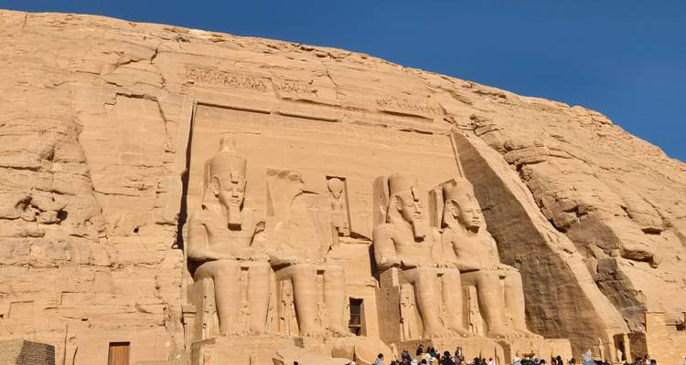 Door de zon beschenen rotsgevel van Abu Simbel met vier zittende standbeelden van Ramses II uitgehouwen in de klif