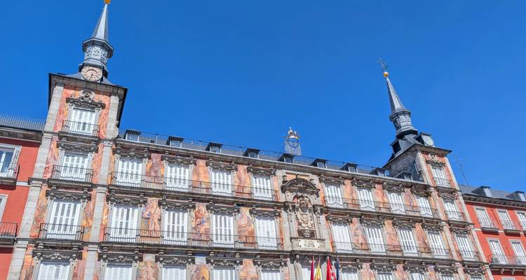 Fachada ornamentada de la Casa de la Panadería en la Plaza Mayor de Madrid resplandeciendo contra un cielo azul profundo.