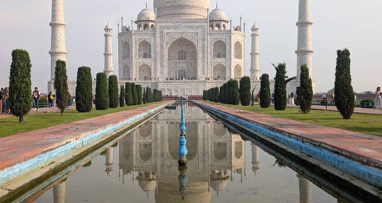 Iconische Taj Mahal perfect weerspiegeld in zijn lange centrale vijver met verzorgde tuinen op een rustige dag