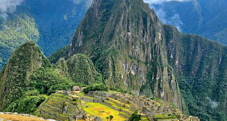 Klassischer Panoramablick auf die Ruinen von Machu Picchu, eingebettet zwischen steilen grünen Andengipfeln