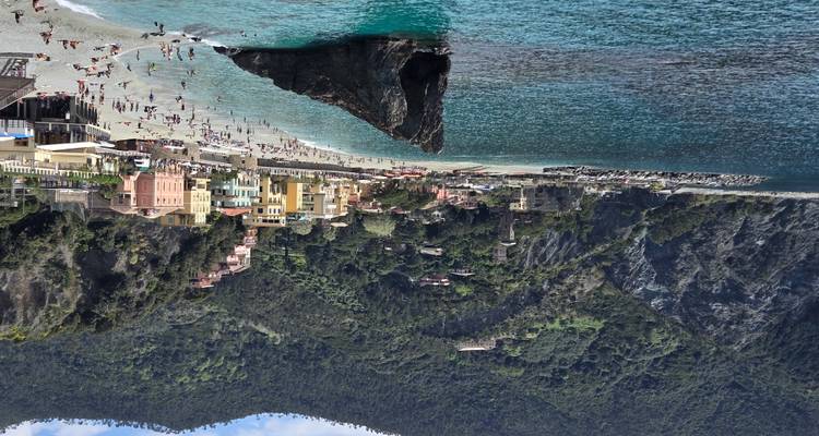Playa de Monterosso al Mare con formación rocosa icónica y agua turquesa rodeada de acantilados