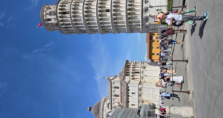 Tour penchée de Pise et place de la cathédrale animée de touristes sous un ciel bleu dégagé.