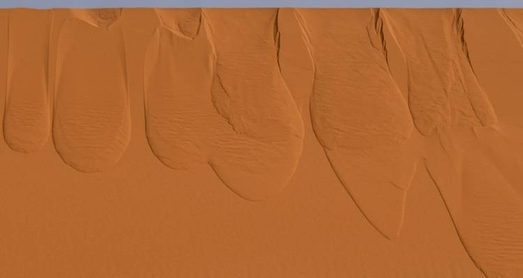 Aerial view of smooth orange sand dunes with elegant wind-carved ridges in the desert.