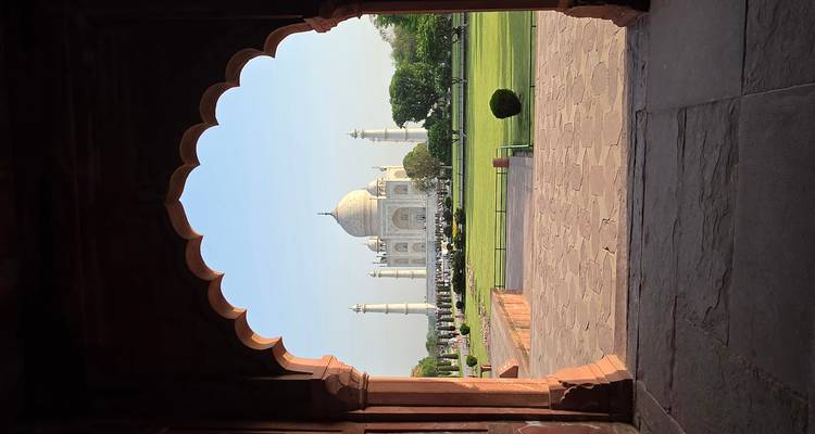 De Taj Mahal perfect omlijst door een Mogolse boog in zacht ochtendlicht.