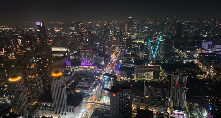 Horizon nocturne spectaculaire de Bangkok avec d'innombrables gratte-ciel illuminés et avenues animées vus depuis un toit.
