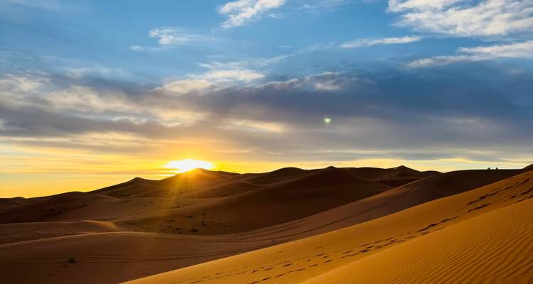 Amanecer dorado sobre las ondulantes dunas de arena del Sahara proyecta largas sombras y luz cálida