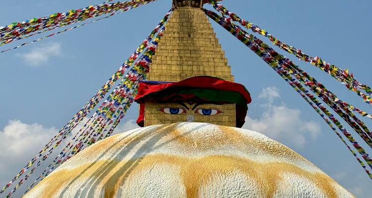Les yeux emblématiques de Bouddha sur la stupa dorée de Swayambhunath ornée de drapeaux de prière colorés