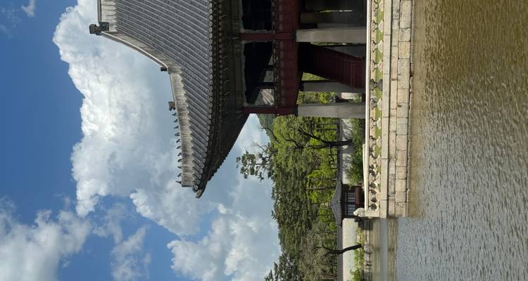 Pabellón tradicional Gyeonghoeru sobre un estanque espejo con bosque de fondo y nubes esponjosas