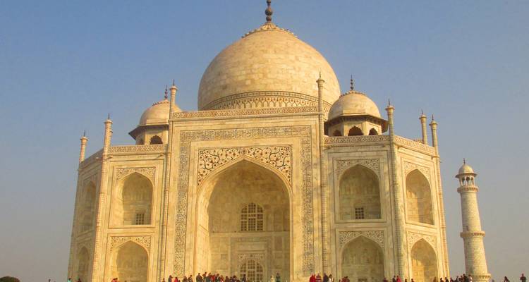Le majestueux Taj Mahal en marbre blanc avec des foules à sa base sous un ciel dégagé