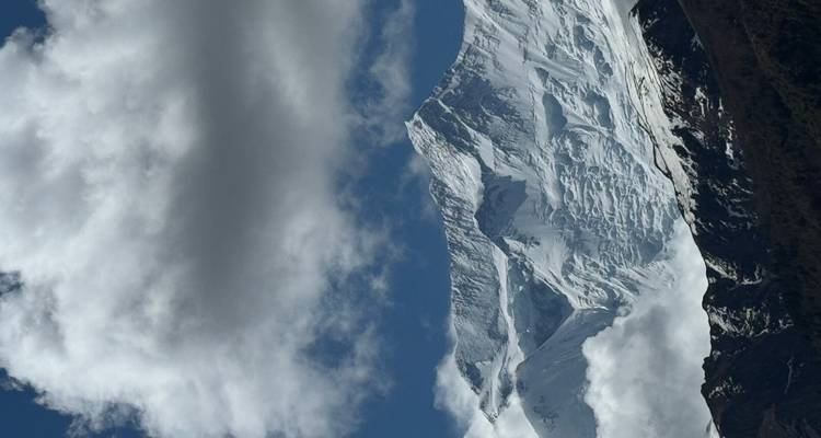 Dramático pico del Himalaya cubierto de nieve bajo nubes ondulantes