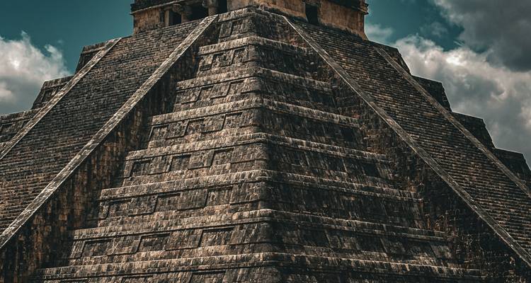 Gros plan dramatique des marches en pierre et des terrasses de la pyramide de Chichen Itza sur un ciel aux teintes sombres