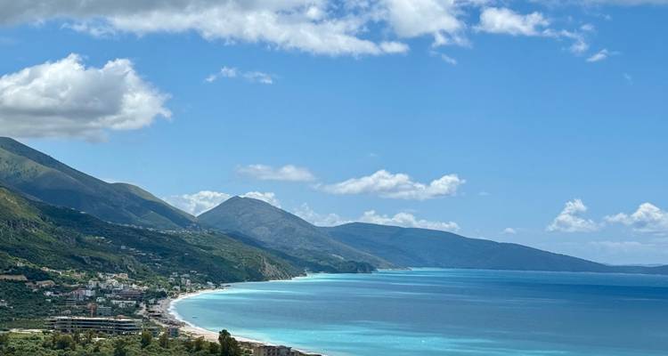 Littoral adriatique turquoise avec des montagnes escarpées et de petites villes côtières sous un ciel lumineux.