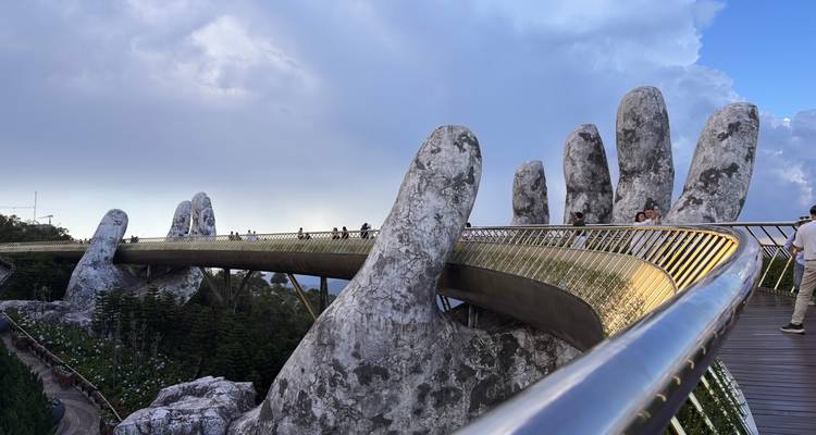 El famoso Puente Dorado sostenido por manos de piedra gigantes se extiende sobre las copas de los árboles envueltas en niebla en Ba Na Hills.