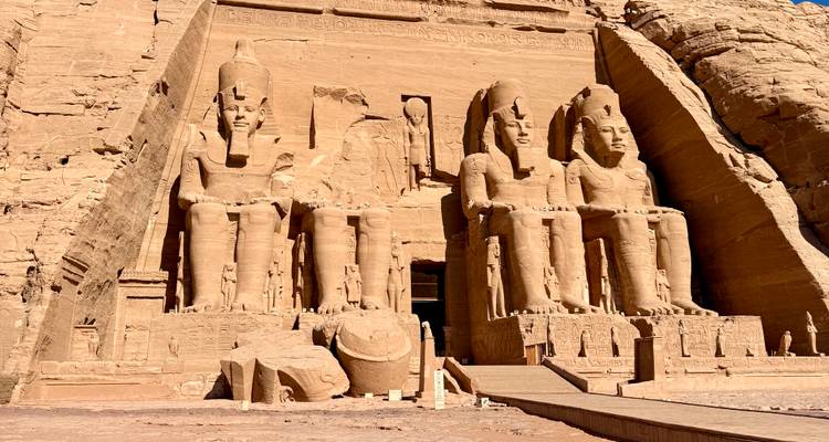 Enormes estatuas sentadas talladas en la fachada del templo de Abu Simbel bajo un cielo despejado