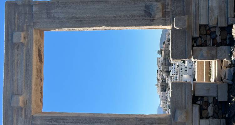 Portail en marbre ancien « Portara » encadrant la vieille ville de Naxos sur fond de ciel bleu éclatant.