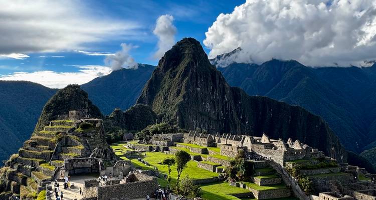Vue emblématique des ruines du Machu Picchu perchées sur une crête avec le pic Huayna Picchu et les Andes couronnées de nuages en arrière-plan