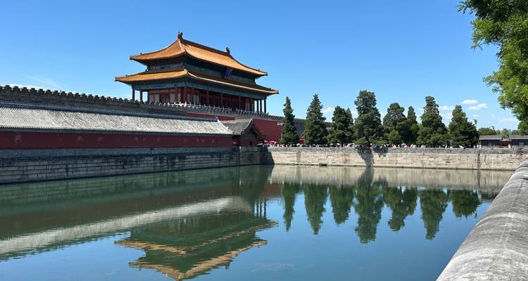 El reflejo del foso de la Torre de la Esquina de la Ciudad Prohibida bajo un cielo azul claro de Beijing.