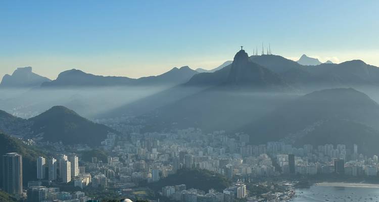Les rayons de brume matinale tranchent entre les montagnes de Rio de Janeiro avec le Christ Rédempteur visible au-dessus de la ville.