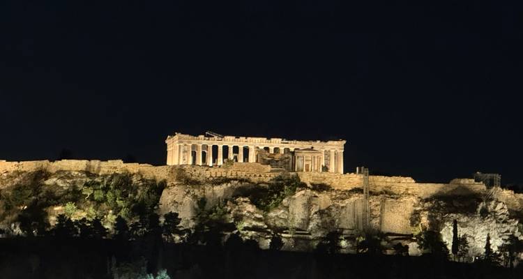 The Parthenon atop the Acropolis illuminated against a dark night sky