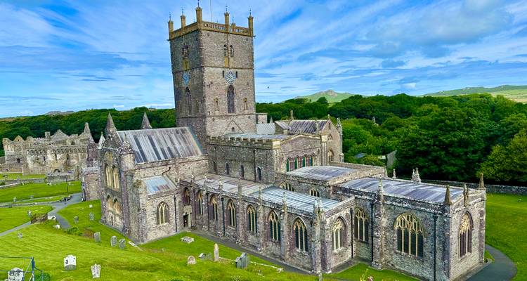 Een prachtig uitzicht van bovenaf op de St Davids Cathedral en omringende stenen structuren in het zachte ochtendlicht.