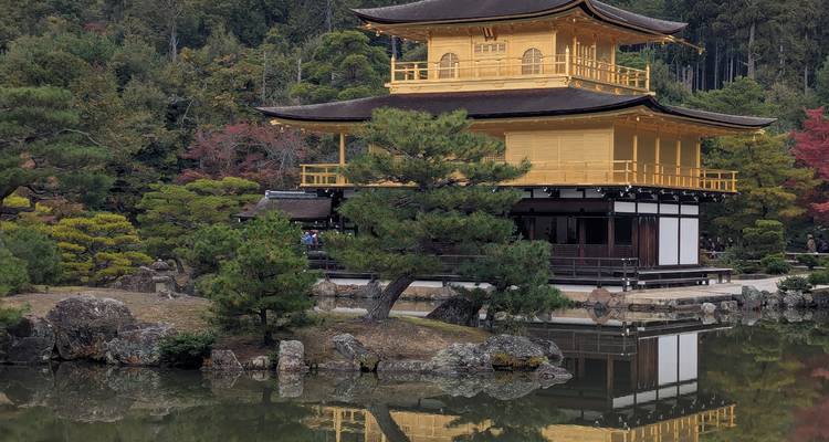 Pavillon d'Or (Kinkaku-ji) se reflétant dans un étang tranquille entouré d'arbres d'automne à Kyoto.