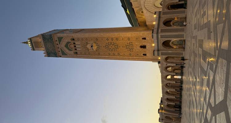 Majestic Hassan II Mosque minaret rises above expansive marble plaza at dusk in Casablanca