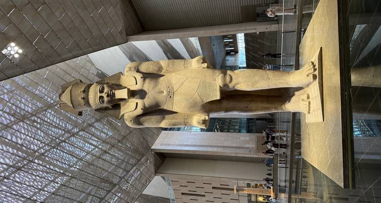 Kolossaal standbeeld van Ramses II in het Grand Egyptian Museum met bezoekers in de buurt