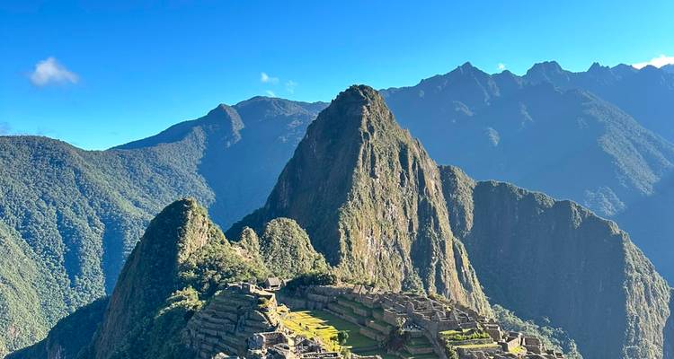 Iconic Machu Picchu terraces and Huayna Picchu peak rise majestically above lush cloud forest.