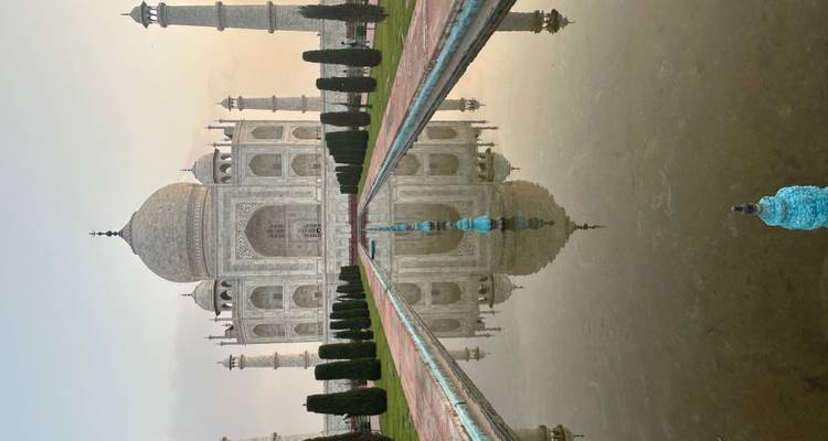 Symmetrisch uitzicht op Taj Mahal weerspiegeld in centraal bassin bij zonsopgang met zachte pastelkleurige hemel