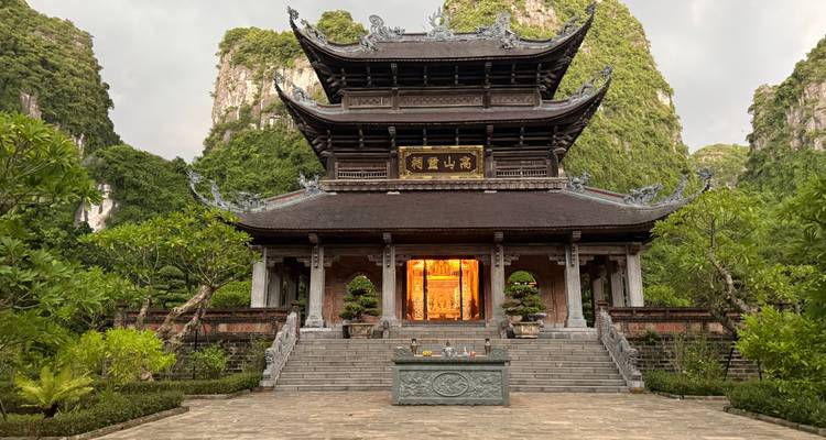 Symmetrisch uitzicht op een sierlijke boeddhistisch tempel tussen imposante kalksteenrotsen.