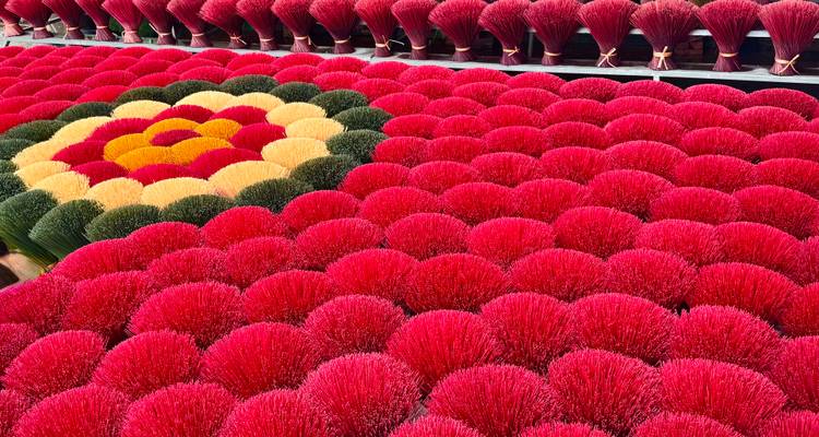 Manojos de incienso organizados en un patrón de flor geométrica con color rojo dominante.