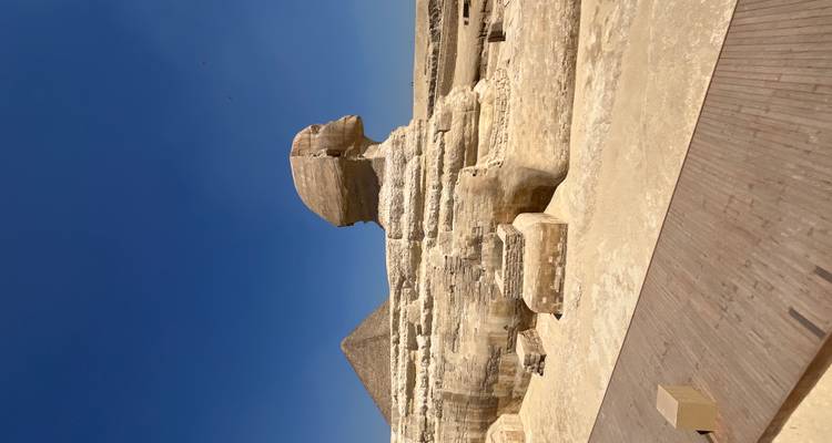 Profil iconique du Grand Sphinx avec la Pyramide de Khafre en arrière-plan sous un ciel dégagé.