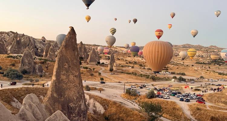 Des dizaines de montgolfières aux couleurs éclatantes s'élèvent au-dessus du paysage rocheux des cheminées de fée de Cappadoce à l'aube.
